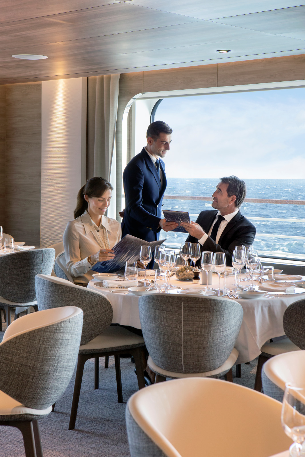 Image retouchee / retouched photograph.  Restaurant Gastronomique Nuna (la terre) - Pont 5 - A l?arriere du pont 5 le Nuna restaurant gastronomique de 484 m? peut accueillir l?ensemble des passagers en un seul service. Elegance et raffinement sont au rendez-vous de vos petits-dejeuners dejeuners et diner servis a la carte. La deuxieme passerelle du navire est situee au fond du restaurant : derriere ses larges vitres vous etes aux premieres loges pour observer l?equipage lors de ses man?uvres. Capacite : 245 - Cuisine gastronomique francaise et internationale - Plats-signatures Alain Ducasse - Cave a vins fins - Mobilier Ligne Roset -  Porcelaine francaise Bernardaud et verrerie d?Elne